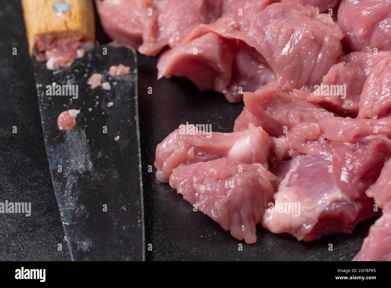 Affettare il maiale o manzo con un coltello sul tavolo in close-up.preparazione di piatti di carne e cibo products.pezzi di carne rossa per il kebab di shish, barbecue Foto Stock