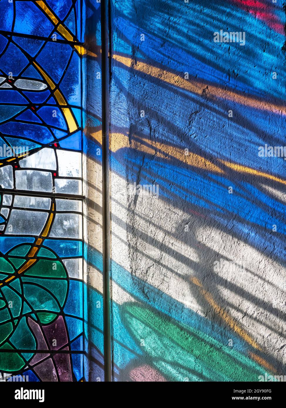 Luce del sole attraverso una moderna vetrata in una chiesa Suffolk, Regno Unito. Foto Stock