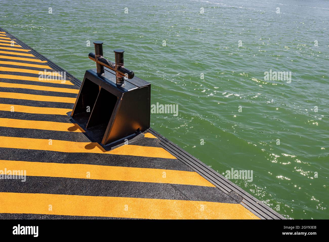 Primo piano di una banchina arancione e nera con un grande bullard metallico per l'ormeggio dei traghetti o del vaporetto nella laguna veneziana, Venezia, Veneto, Italia Foto Stock