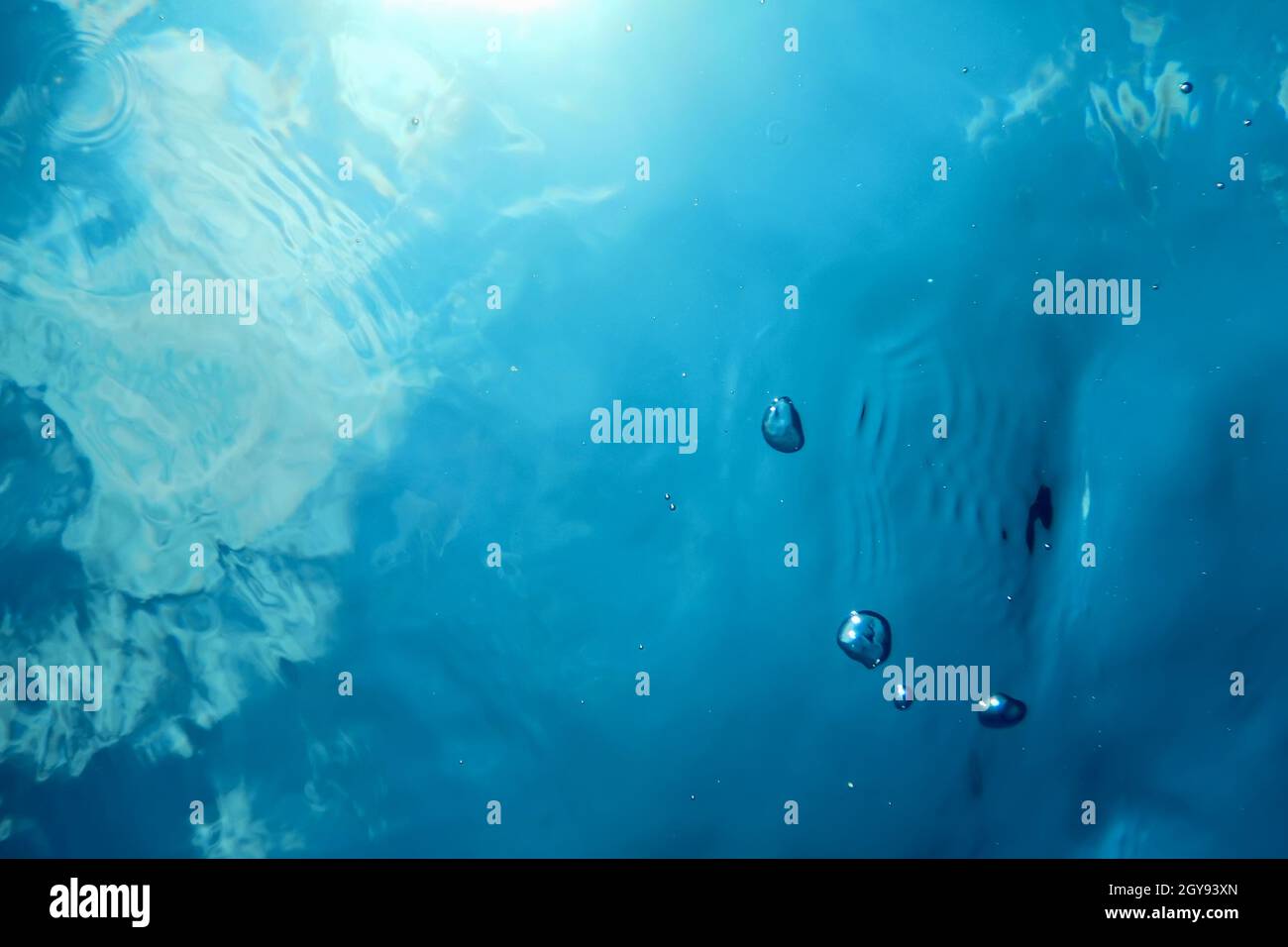 Bolle subacquee luce solare, sfondo subacqueo bolle acqua superficie Foto Stock