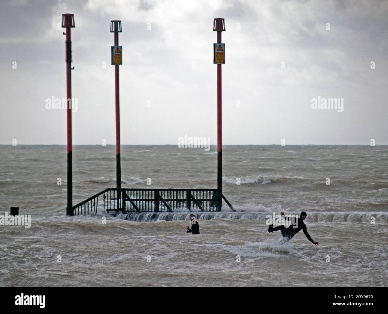 Un surfista prende un tumble nel mare al largo di Brighton Foto Stock