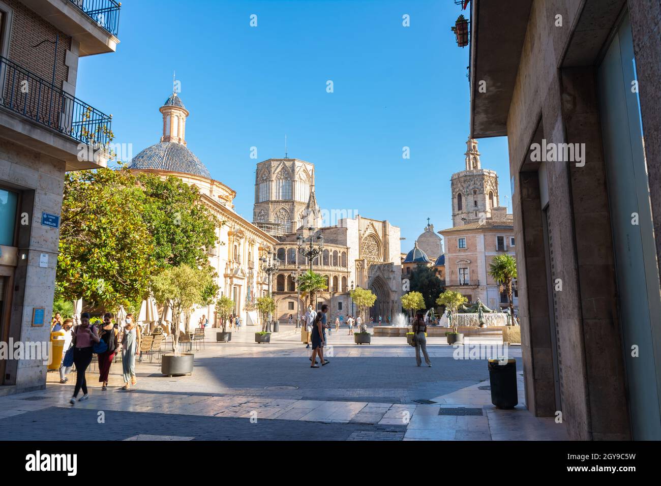 Valencia, Spagna. 7 luglio 2021 - Piazza con la basilica della Vergine, la cattedrale con la cupola ottagonale e il suo campanile, noto come Miguelete. Foto Stock