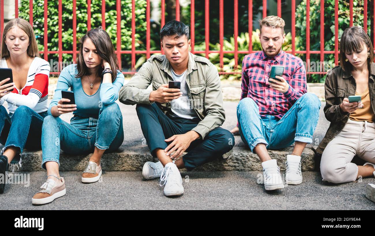 Milenial amici gruppo utilizzando smartphone seduto al cortile università - giovani dipendenti da smartphone mobile - concetto di tecnologia Foto Stock