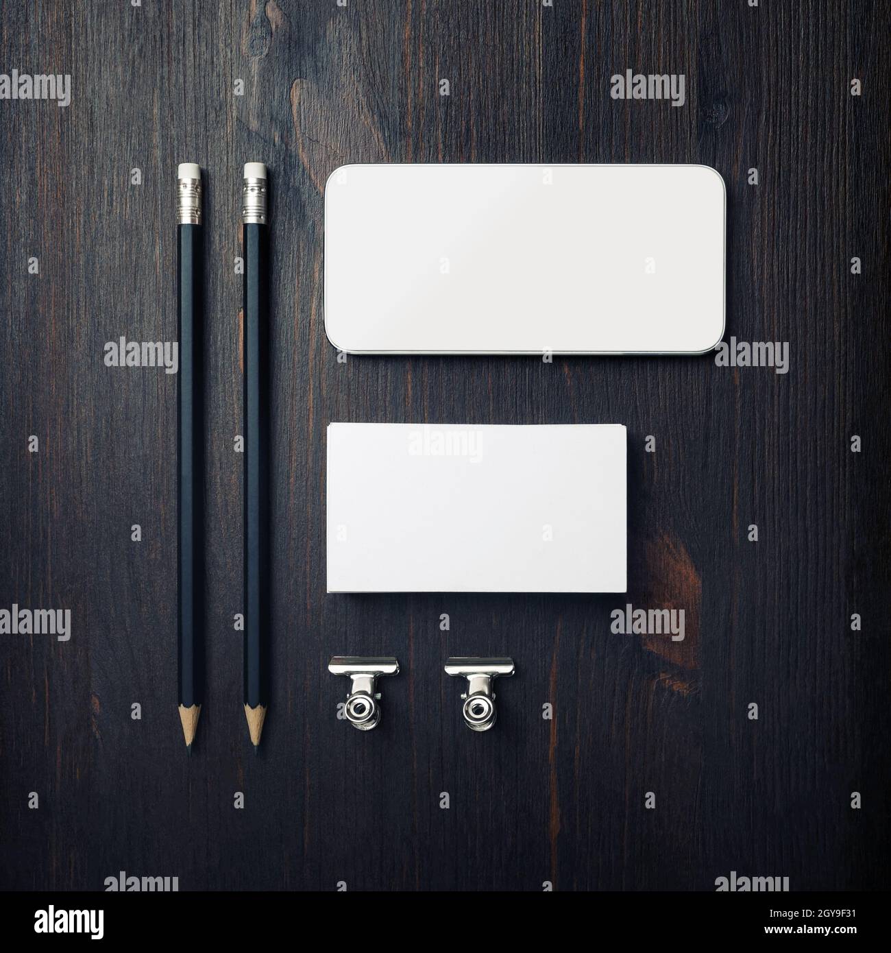 Modello id branding. Biglietto da visita vuoto, smartphone, matite e graffette. Disposizione piatta. Foto Stock