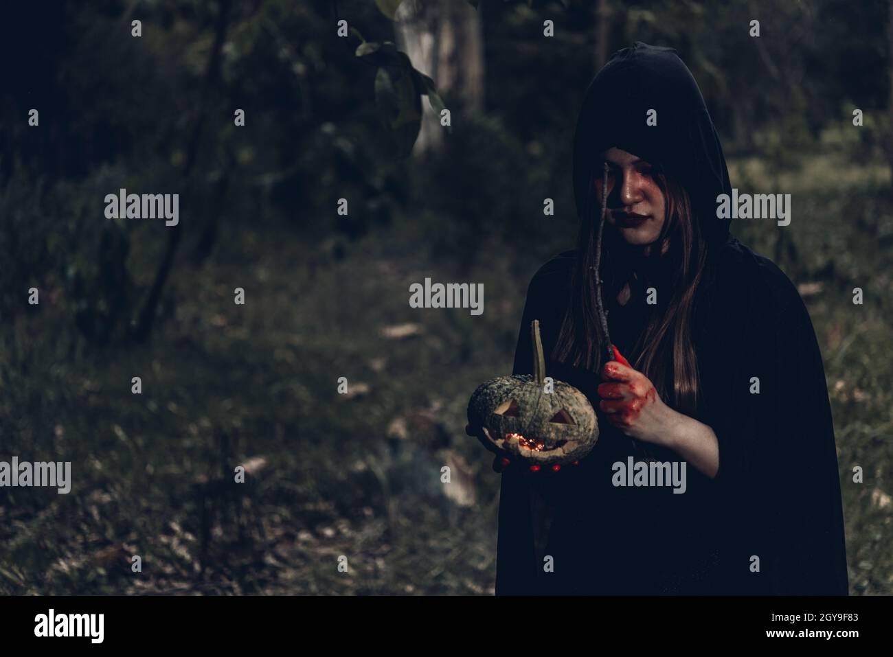 Donna fantasma orrore la sua zucca di tenuta a portata di mano e hanno bacchetta magica, Halloween giorno concetto Foto Stock