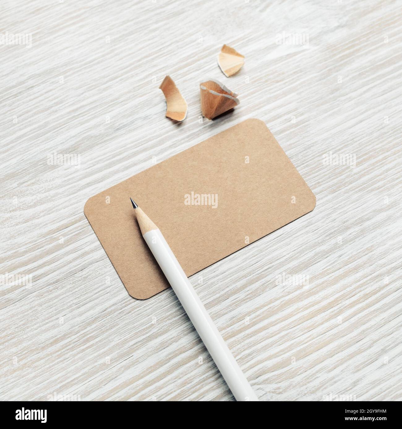 Foto di biglietto da visita vintage vuoto e matita su sfondo di legno chiaro. Mockup per ID. Foto Stock