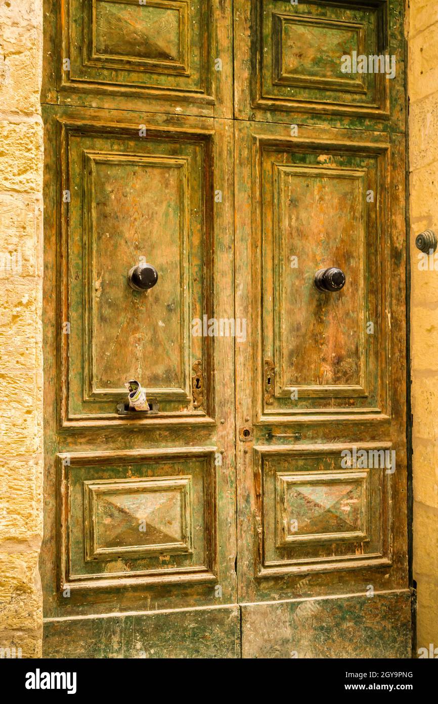 Immagine di una porta in legno verde/giallo fantasia a Valletta, Malta Foto Stock