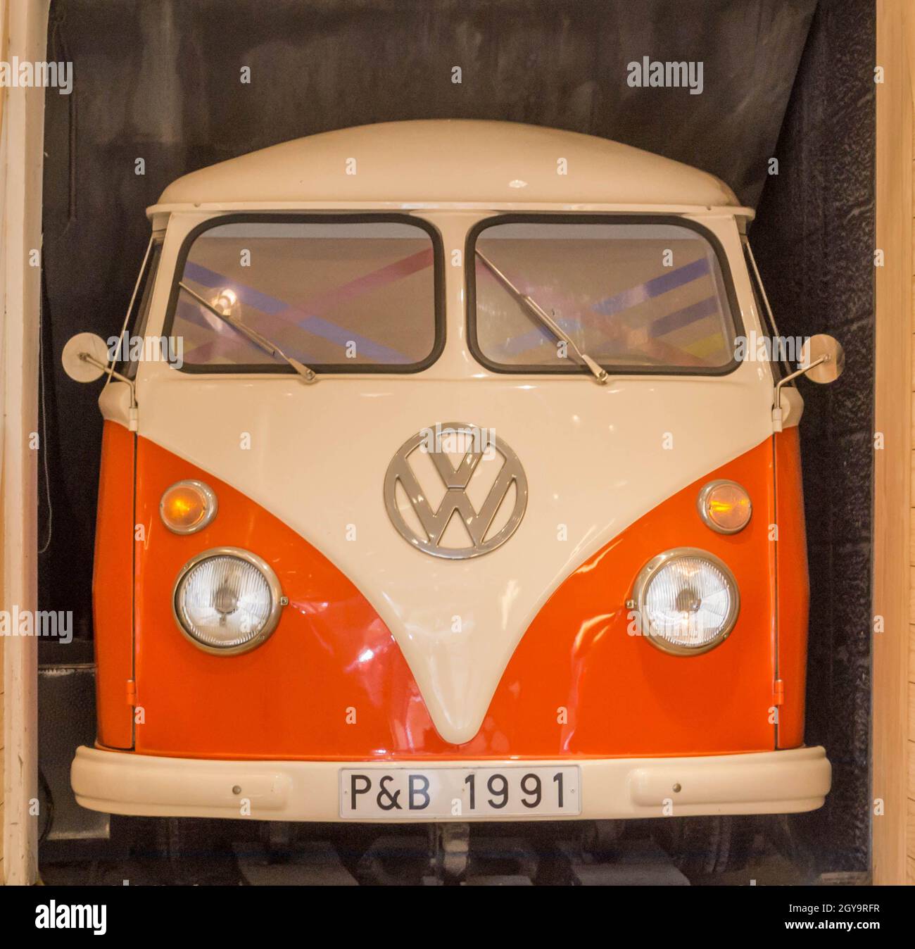 Vista frontale di Orange e bianco VW Kombi/bus/transporter parcheggiato in garage a Valletta Malta. Nessuna gente. Foto Stock