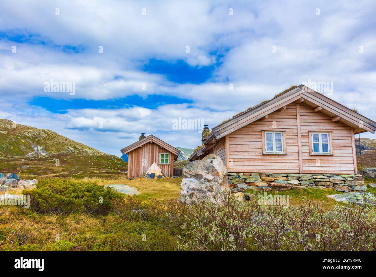 Incredibile Vavatn paesaggio vista panoramica cottage e montagne con neve durante l'estate in Norvegia Hemsedal. Foto Stock