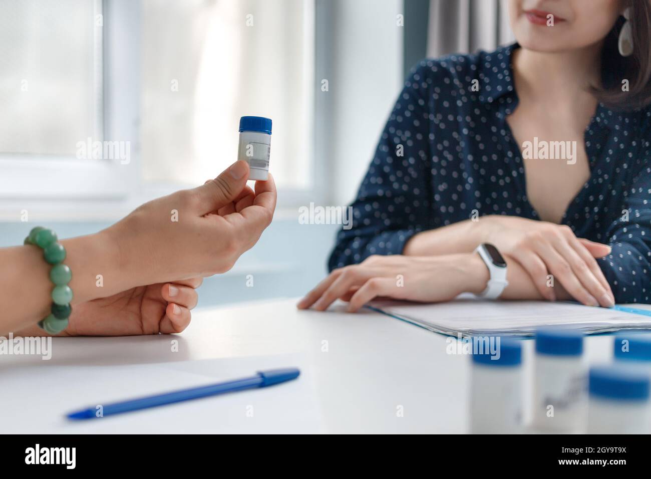 Il medico offre al paziente una medicina omeopatica. Foto Stock