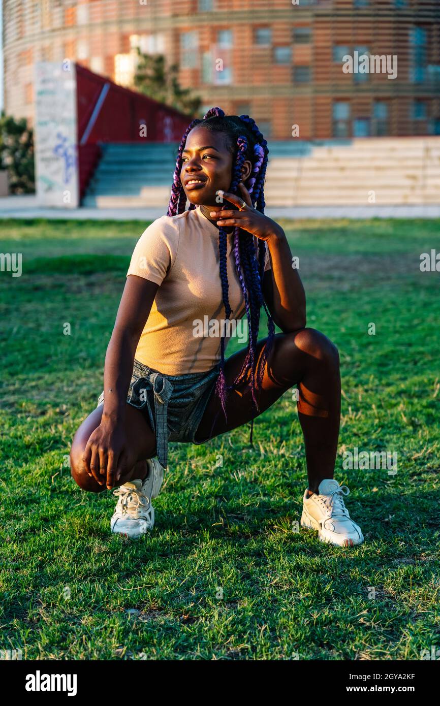 ragazza nera con trecce in posa in un parco Foto Stock