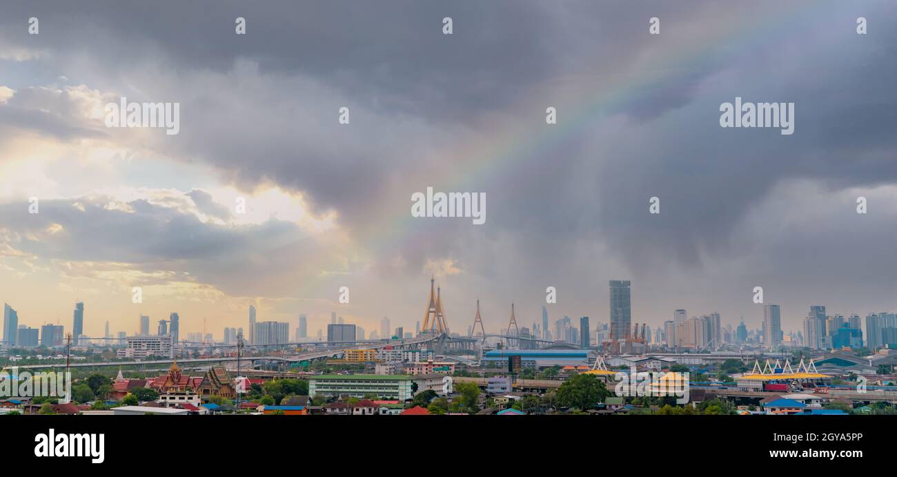Paesaggio urbano di un edificio moderno con autostrada e comunità a Bangkok. Edificio con grattacieli. Skyline urbano. Paesaggio urbano con un arcobaleno sul cielo tempestoso e. Foto Stock