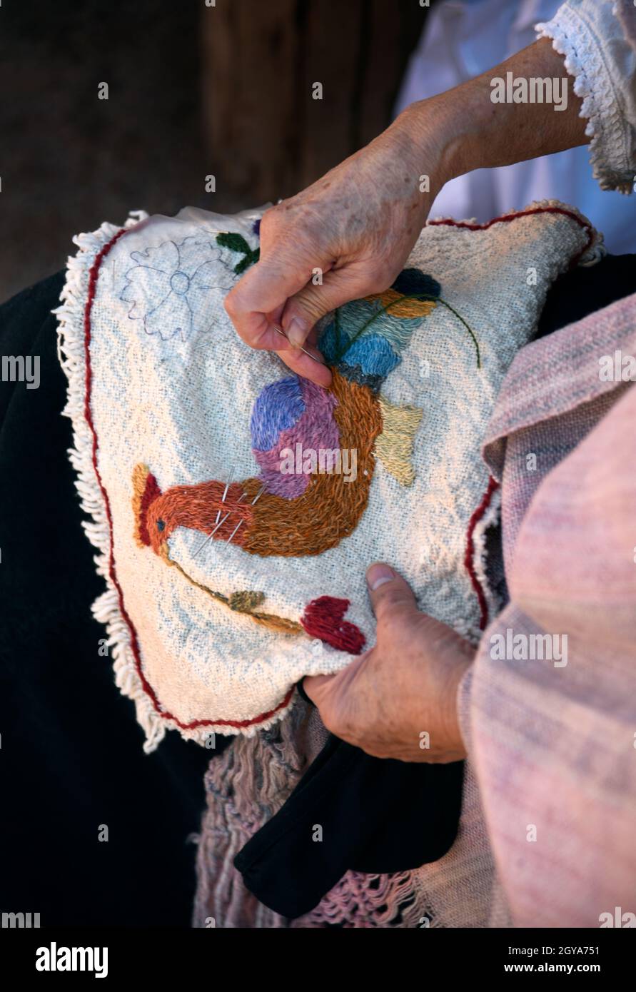 Una donna stitches un tradizionale tessuto ispanico ricamo colcha al complesso di storia vivente El Rancho de las Golondrinas vicino Santa Fe, New Mexico. Foto Stock