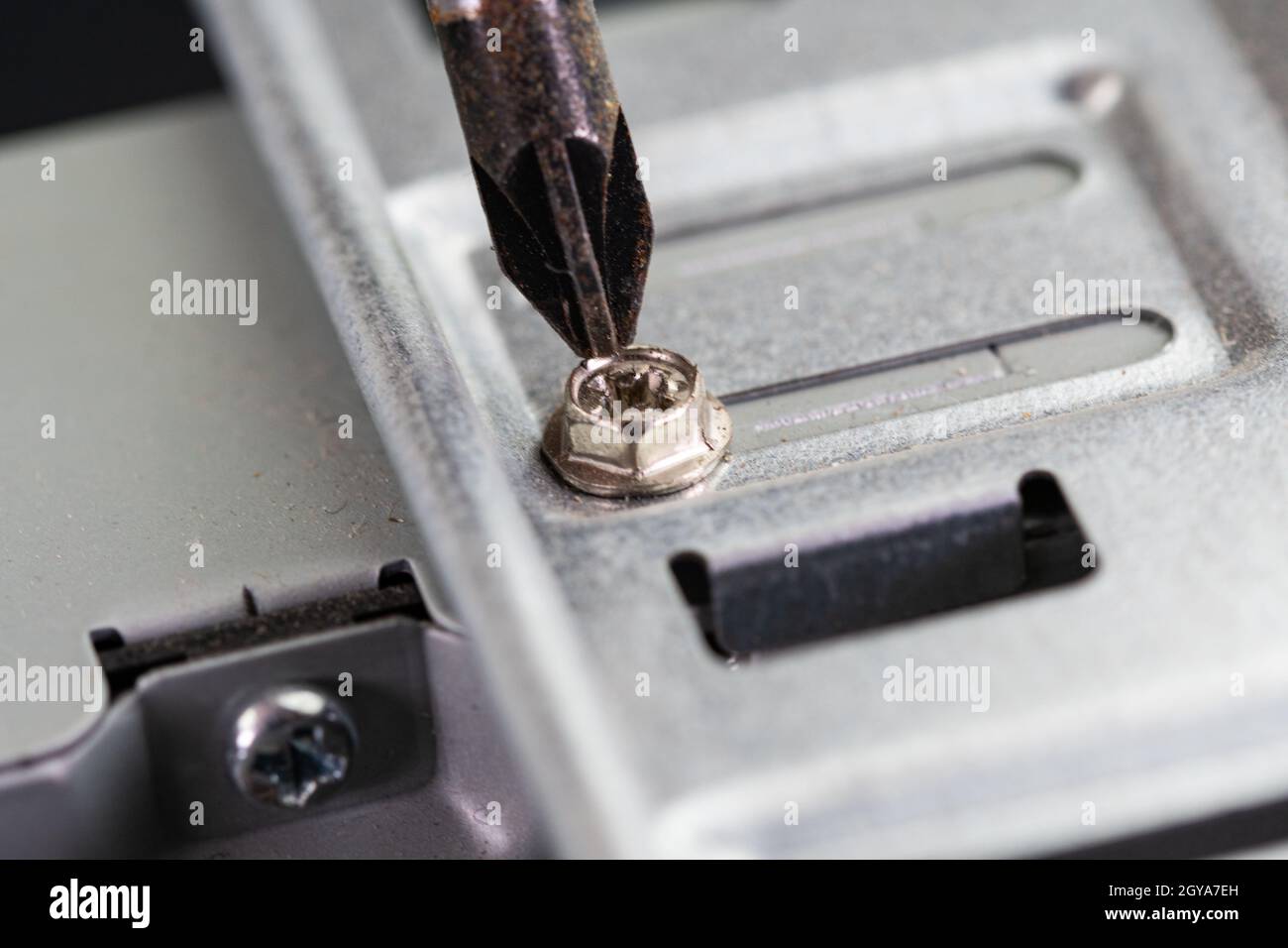 cacciavite che svita una vite di un pc sul lato del disco rigido Foto Stock