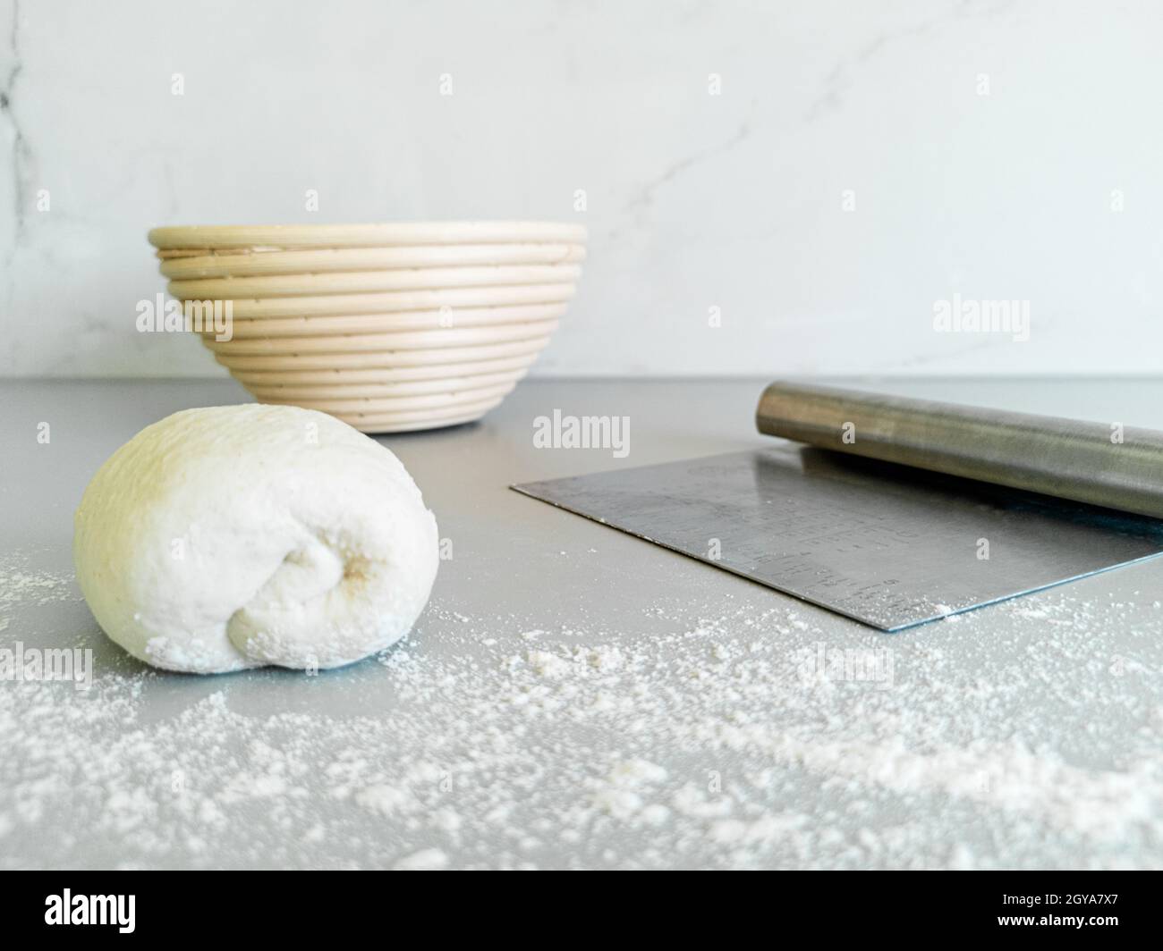 Vista frontale su pasta, paniere di proofing e coltello in metallo per pasta Foto Stock