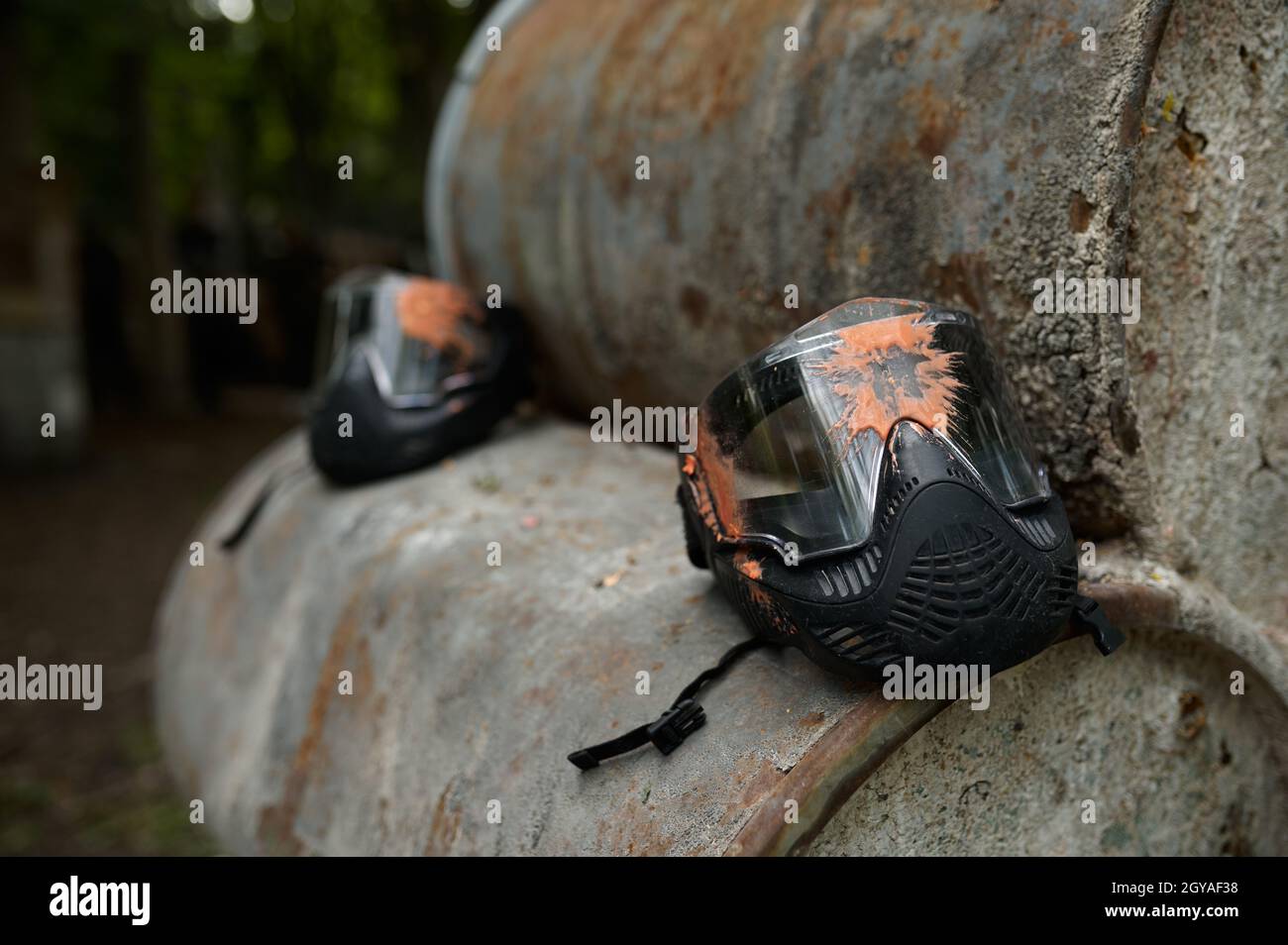 Paintball maschera di protezione primo piano, nessuno, parco giochi nella foresta sullo sfondo. Sport estremi all'aperto, arma pneumatica e proiettili di vernice, militar Foto Stock