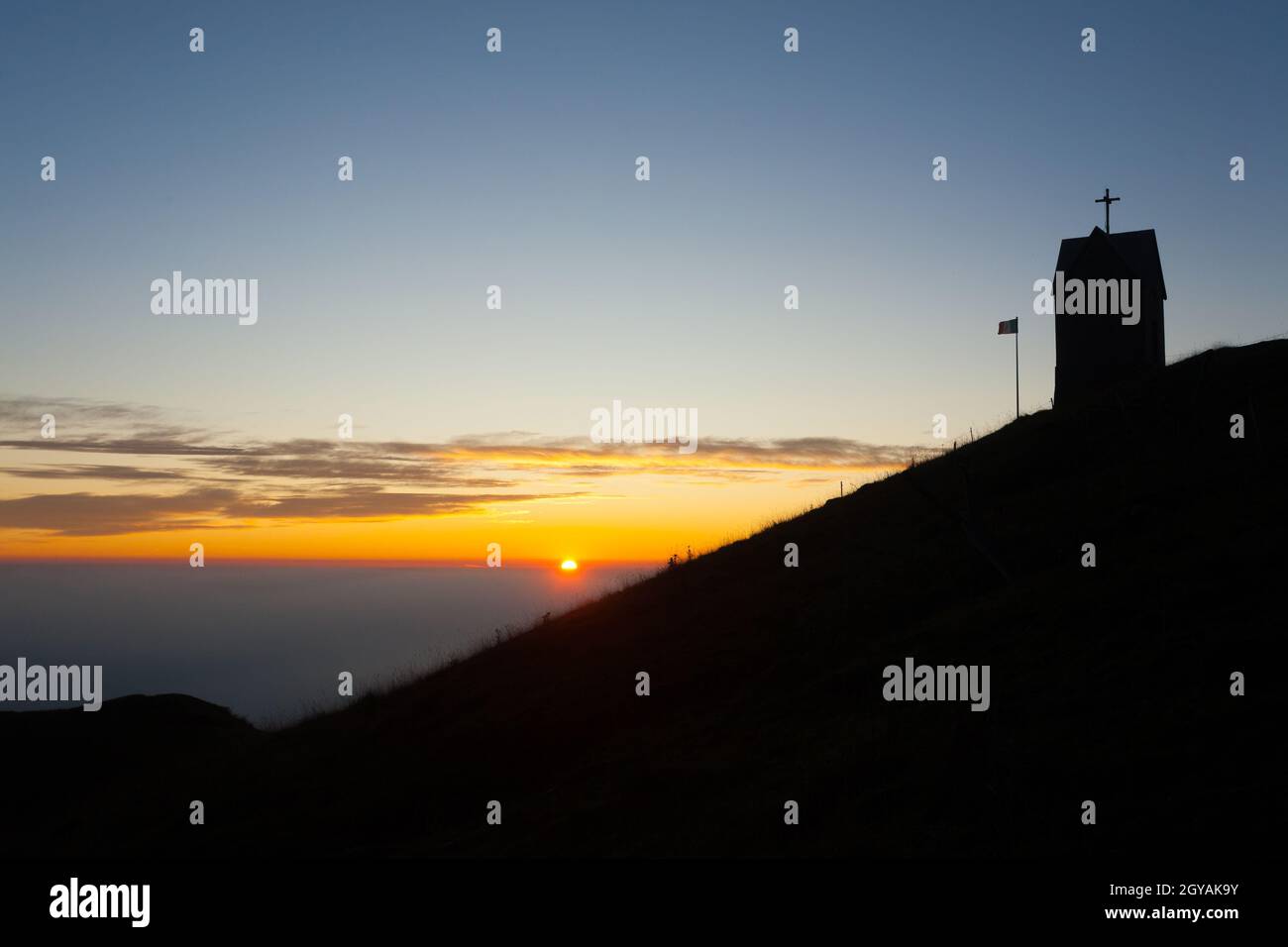 Alba alla piccola chiesa, Monte Grappa paesaggio, Italia. Alpi italiane panorama Foto Stock