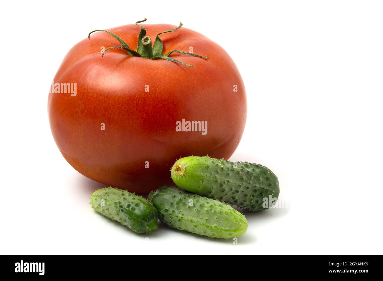 Cetriolini freschi e pomodoro rosso grande isolato su sfondo bianco Foto Stock