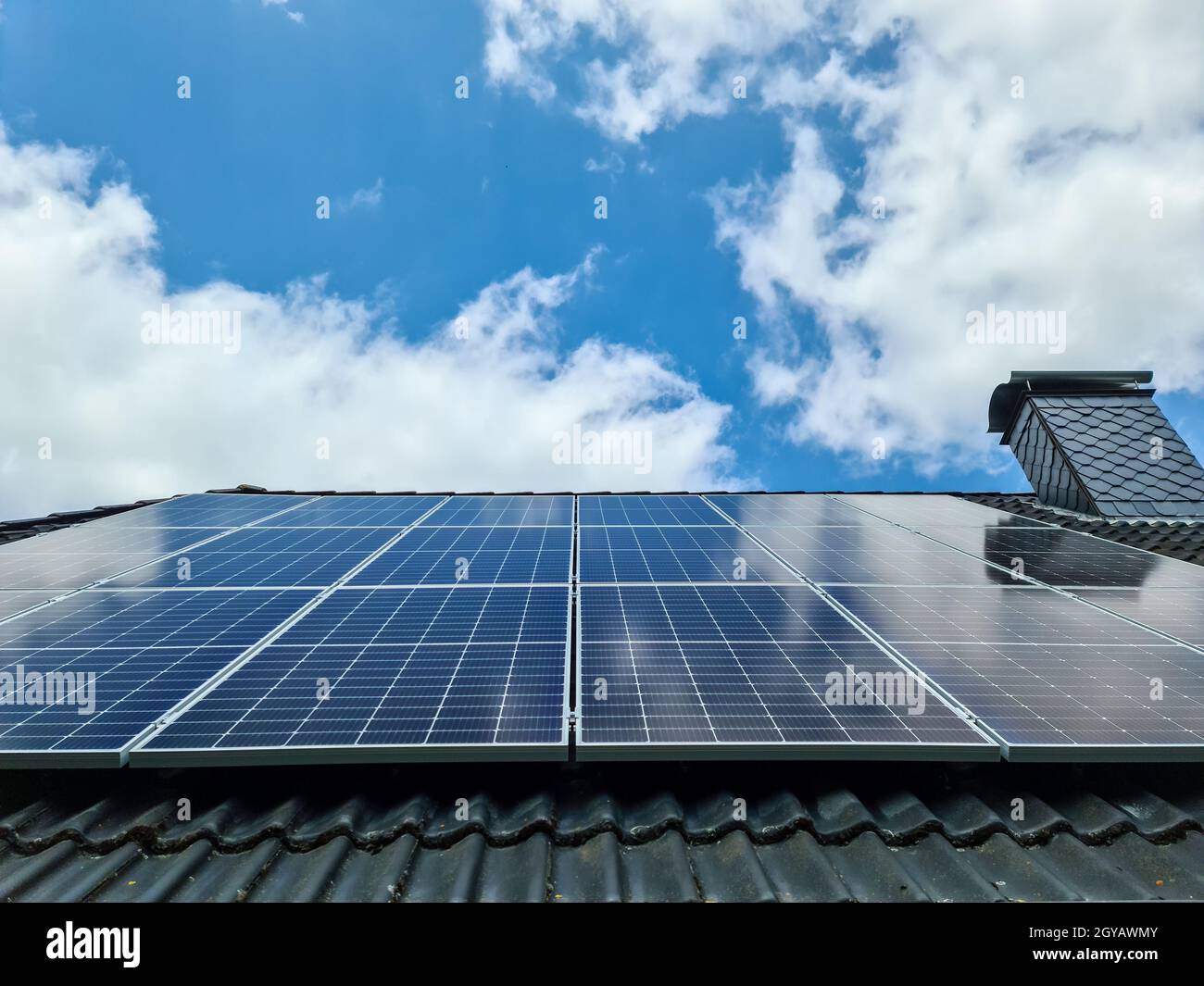 Pannelli solari che producono energia pulita su un tetto di una casa residenziale Foto Stock