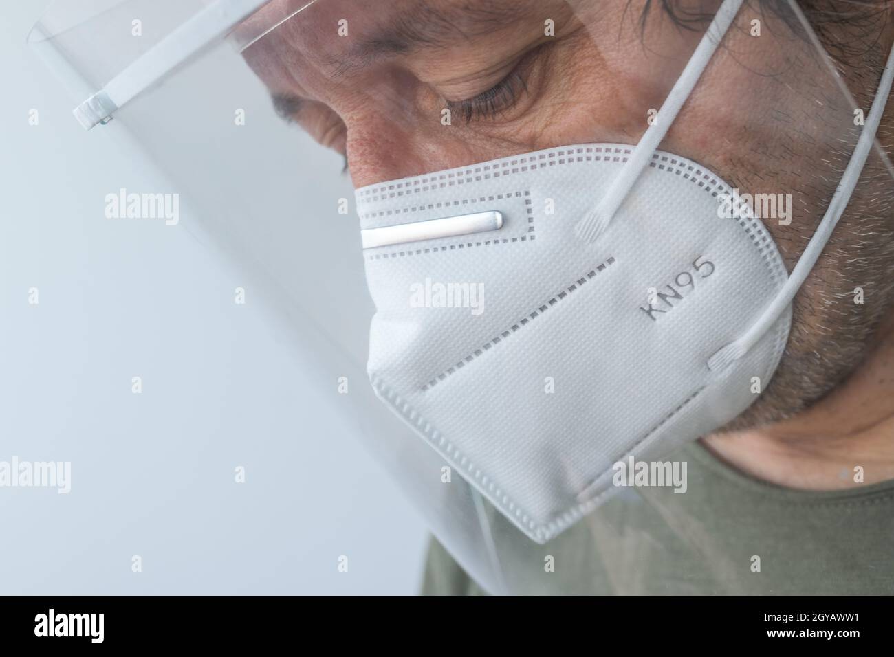 Medico professionista che indossa visiera e maschera respiratoria KN95 durante le pandemie di Covid-19, triste e medico stanco in ospedale Foto Stock