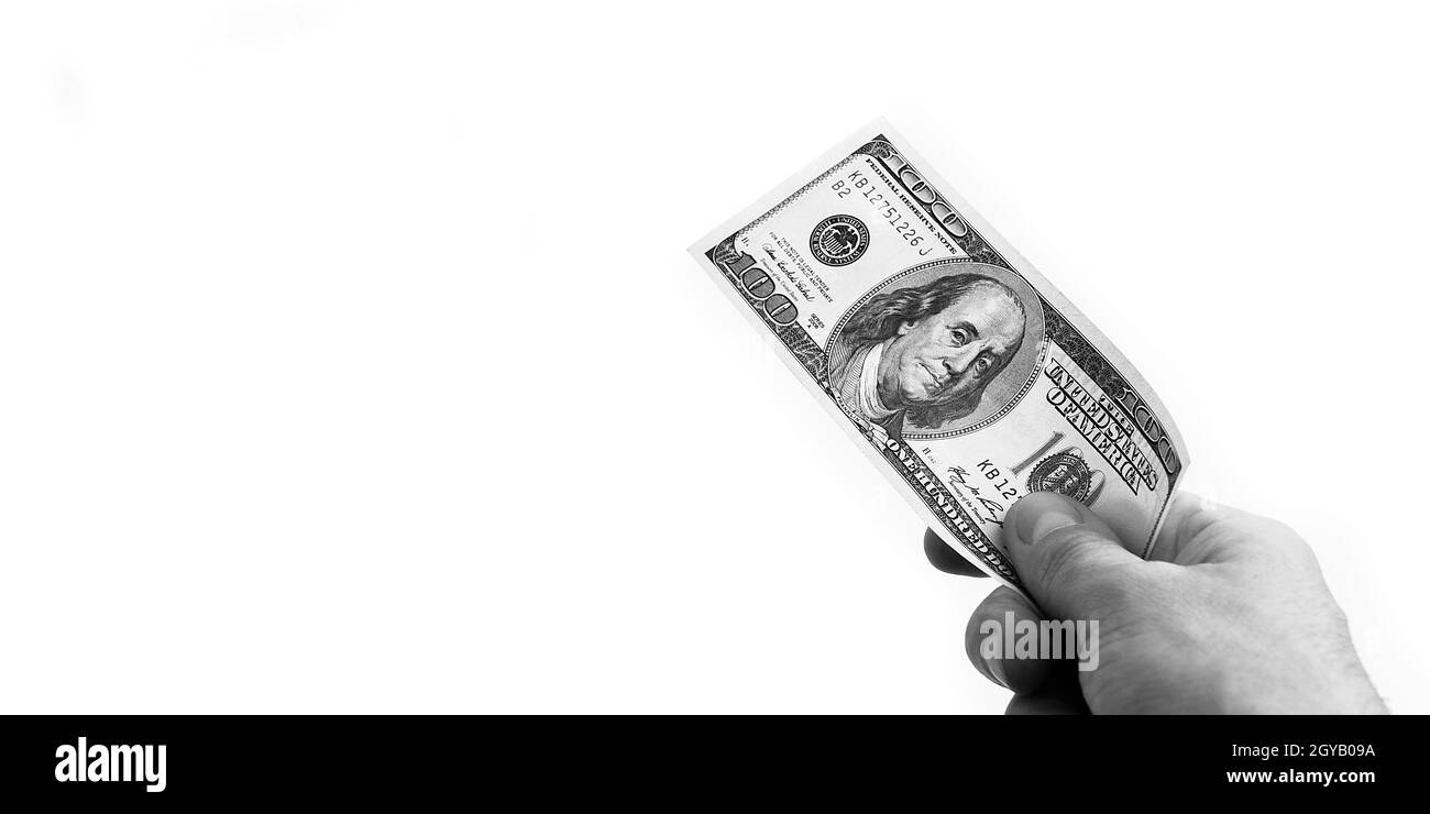 Un conto di cento dollari in mano su sfondo bianco. Isolato. In bianco e nero. Un conto di cento dollari americani. Una fattura è dollari. Il Foto Stock