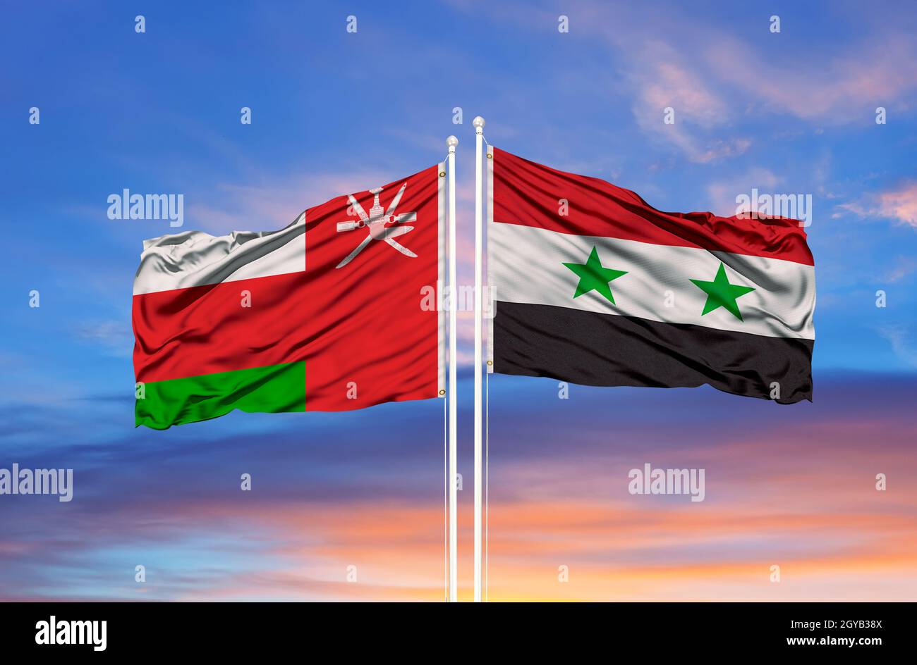 Bandiera dell'Oman e della Siria che sventolano nel vento contro il cielo blu nuvoloso bianco insieme. Concetto di diplomazia, relazioni internazionali Foto Stock