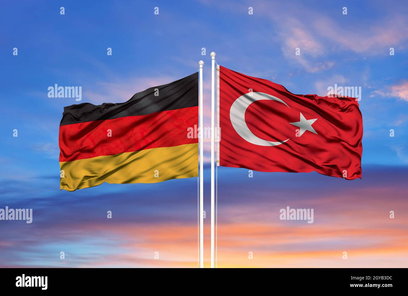 Germania e Turchia due bandiere su palchi e blu nuvoloso cielo Foto Stock