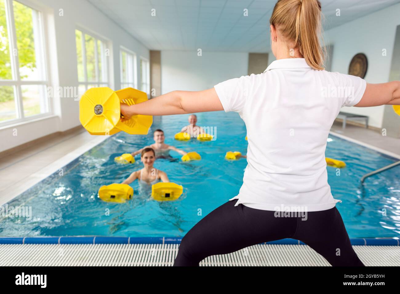 Insegnante o allenatore in acqua ginnastica classe mostrando gli esercizi Foto Stock