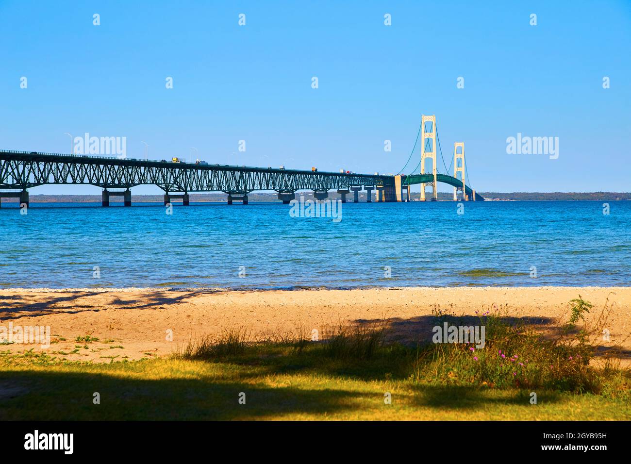 Ponte sospeso gigante sul lago Michigan con onde ondate e una spiaggia di sabbia Foto Stock