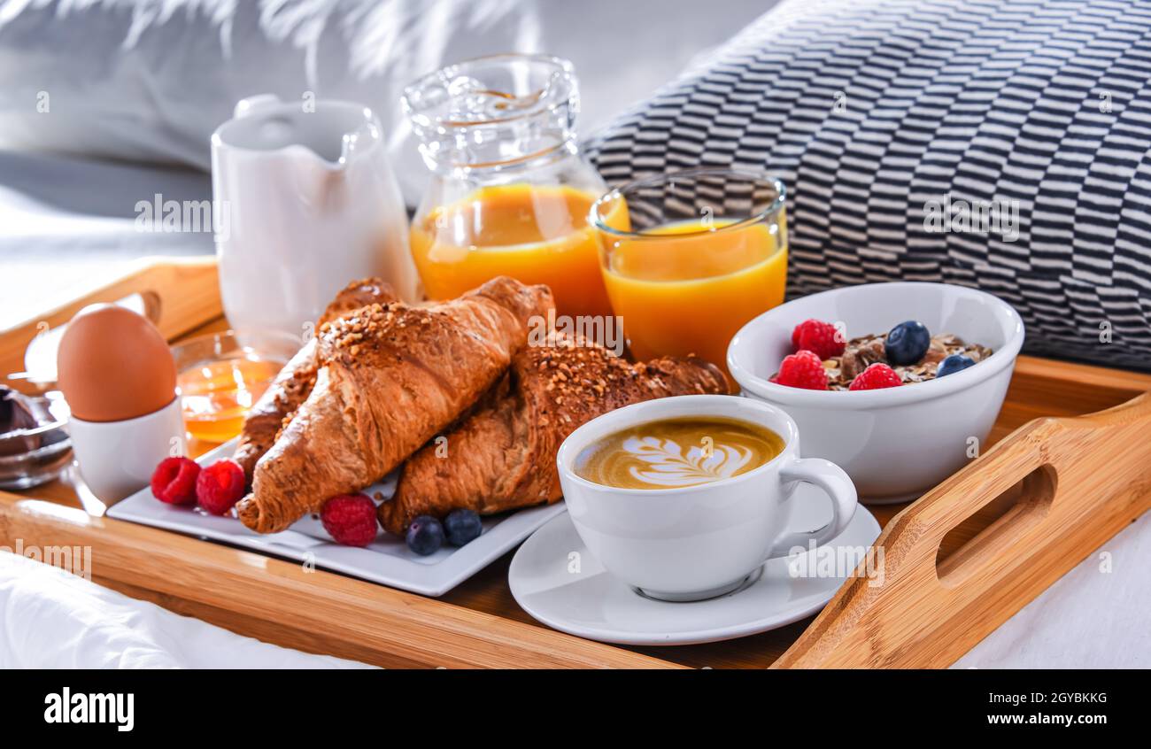Un vassoio con la prima colazione su un letto in una camera d'albergo Foto  stock - Alamy