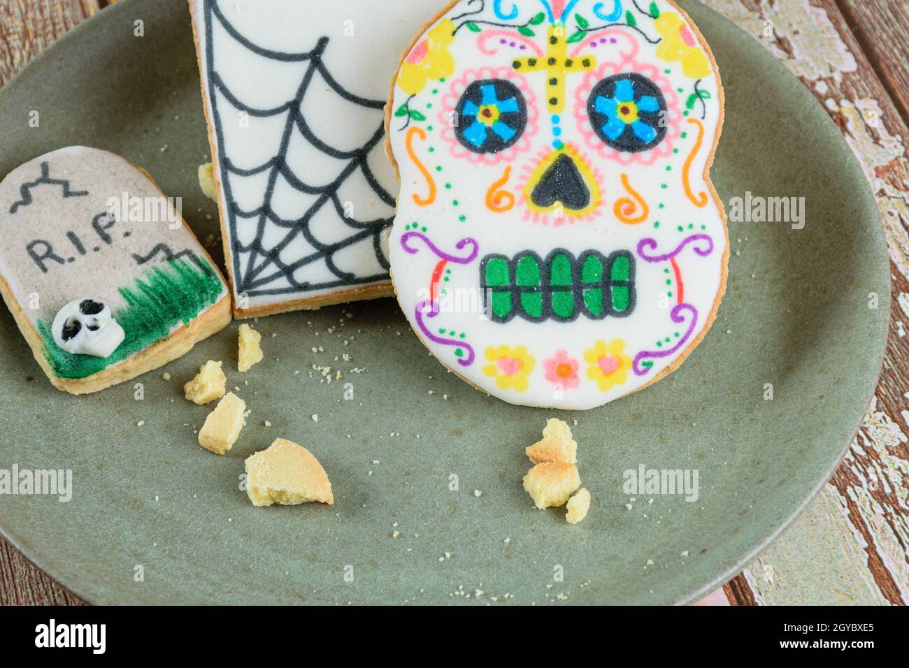 Primo piano di biscotti al burro a tema Halloween su un piatto verde. Foto Stock