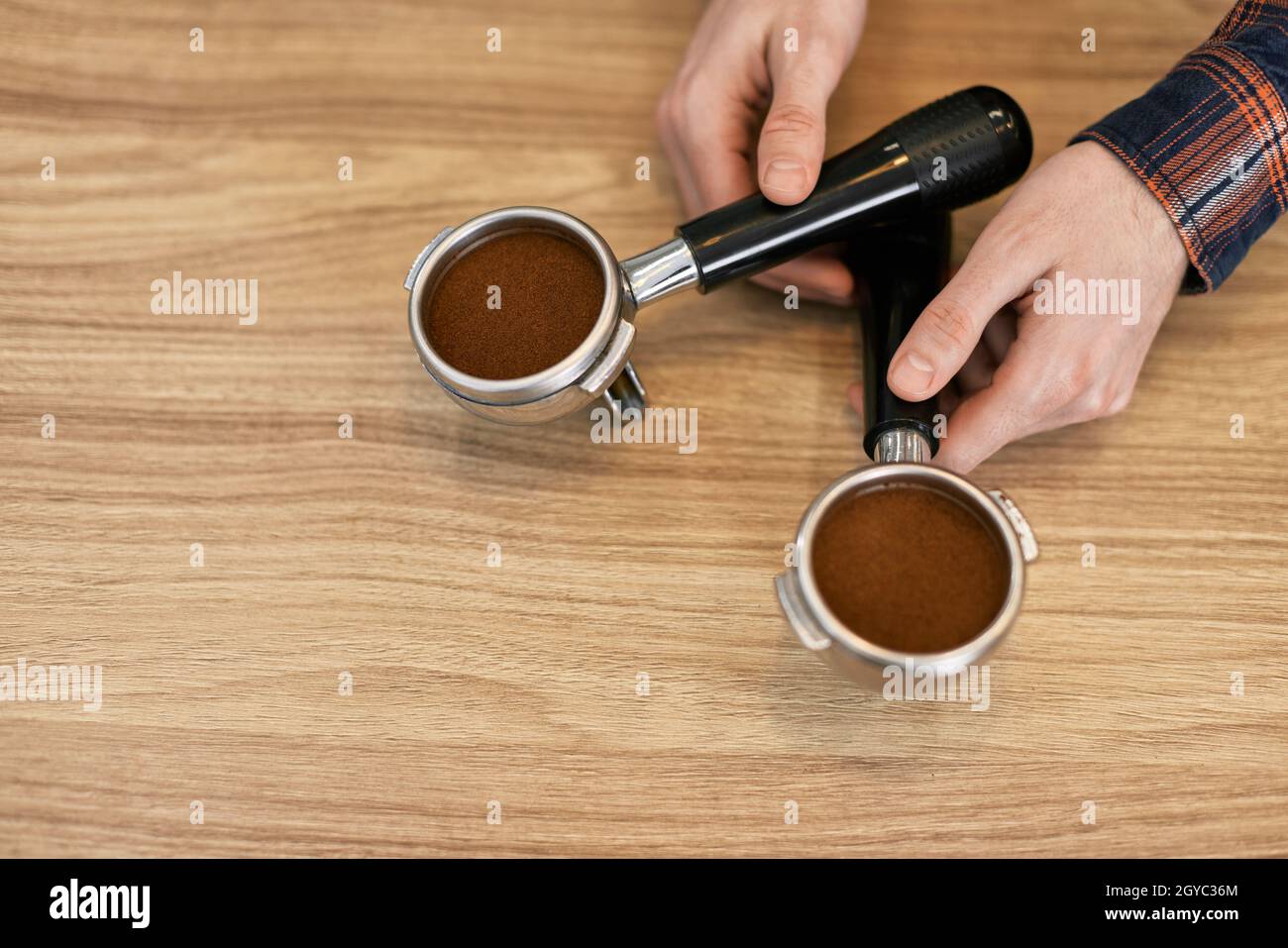due supporti per una macchina da caffè con caffè appena macinato su un tavolo di legno. spazio copia Foto Stock
