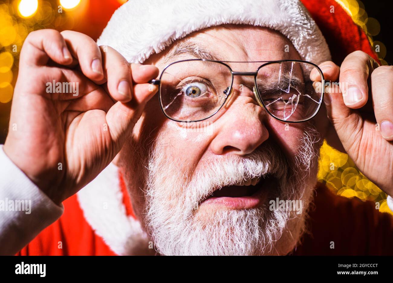 Pubblicità di Natale. Babbo Natale guardando attraverso occhiali spaccati. Santa uomo con vetri rotti Foto Stock