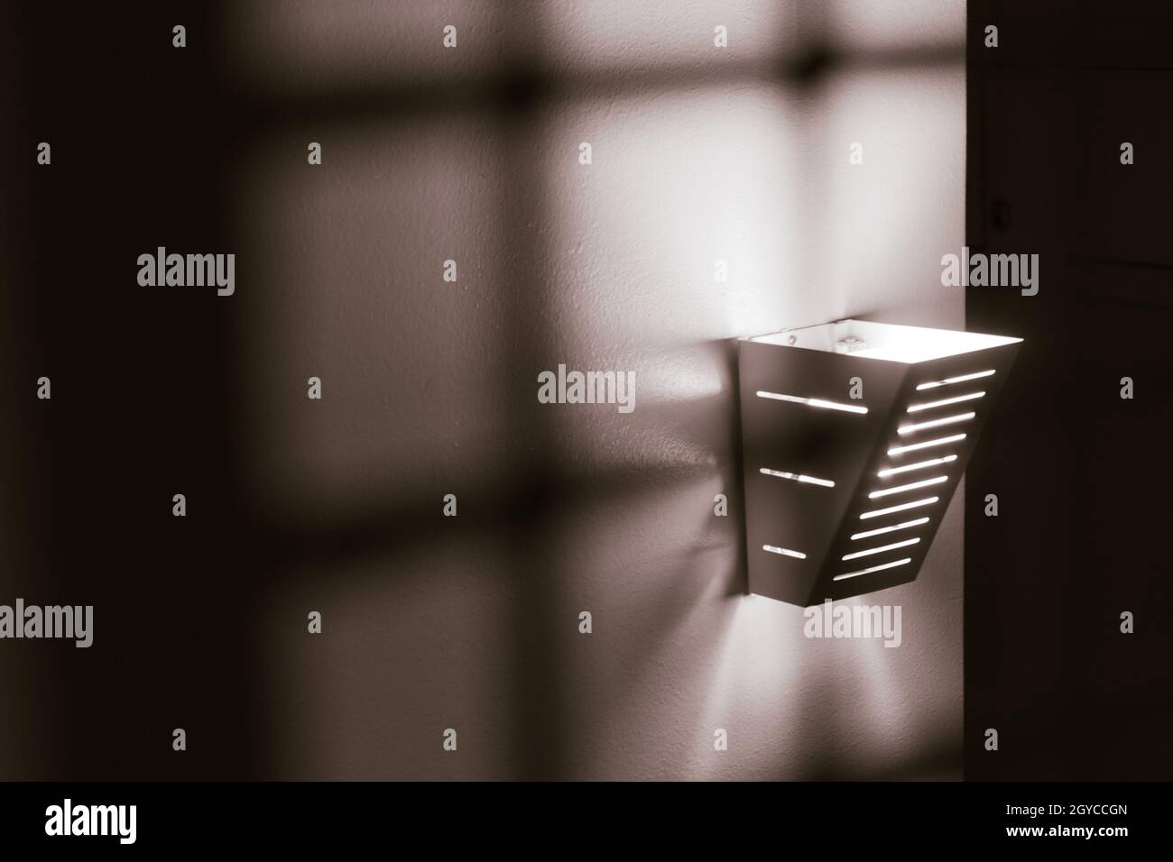 Immagine monocromatica di una luce al tungsteno su una parete testurizzata. Foto di alta qualità Foto Stock