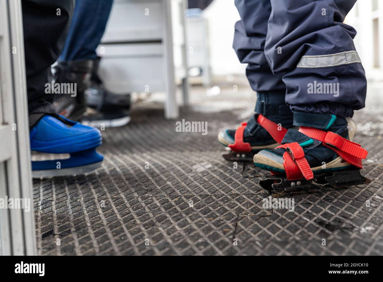 Vista dettagliata dei bambini che indossano scarpe da pattinaggio in  plastica blu in piedi su un tappetino morbido in gomma antiscivolo nello  spogliatoio di pattinaggio Foto stock - Alamy