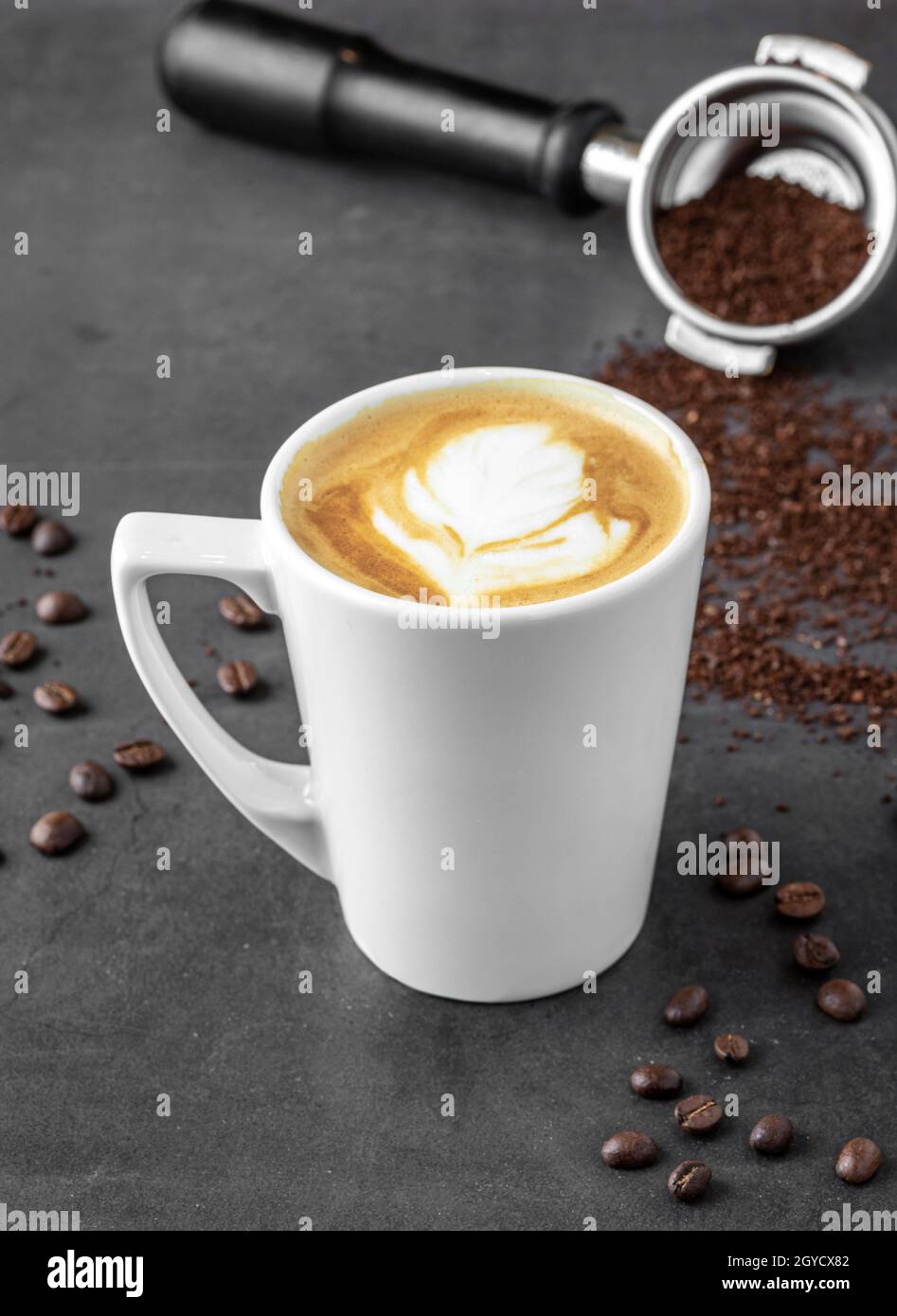 Caffè latte rilassante in una tazza di porcellana bianca su un tavolo in pietra Foto Stock