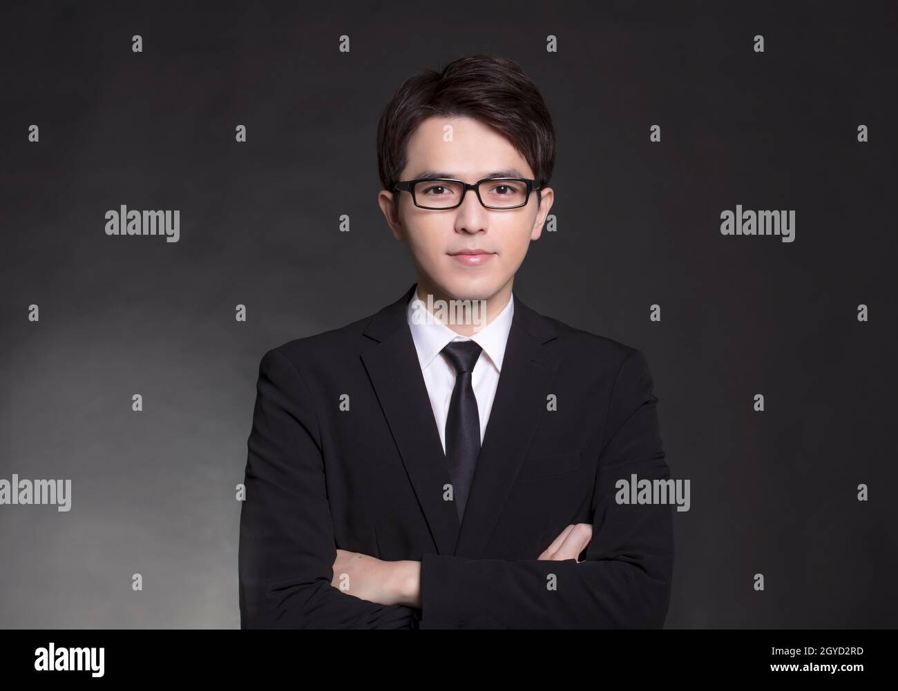 Giovane bell'uomo in abito nero e con occhiali Foto Stock