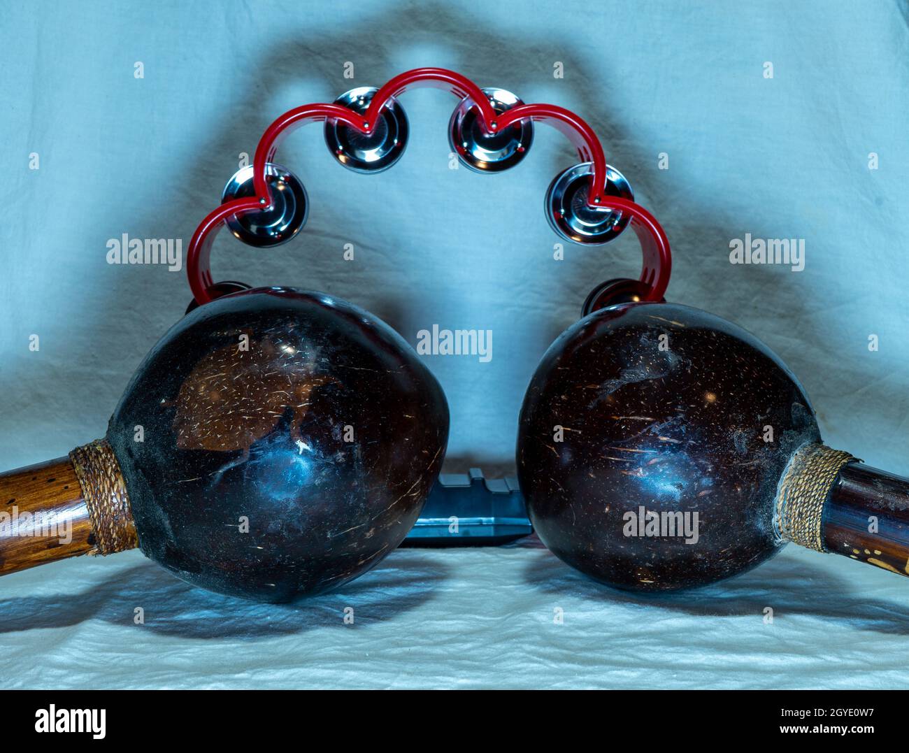 maracas e tamburello posti su uno sfondo che è un tessuto bianco con illuminazione bluastra. Foto di alta qualità Foto Stock