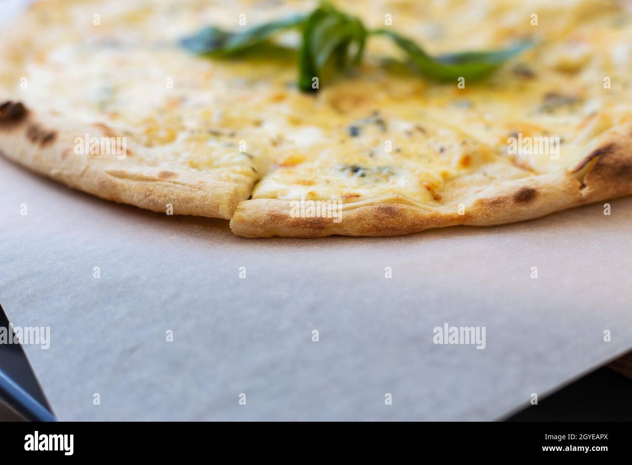 Fragrante pizza italiana di quattro formaggi - parmigiano, blu dor, mozzarella, cheddar, primo piano Foto Stock