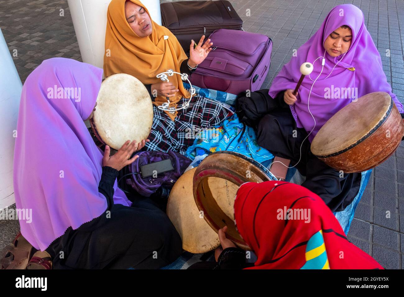 Gli operatori islamici internazionali ospiti, rilassarsi con i loro strumenti musicali durante il loro giorno di riposo settimanale. Tsim Sha tsui, Hong Kong, Cina Foto Stock