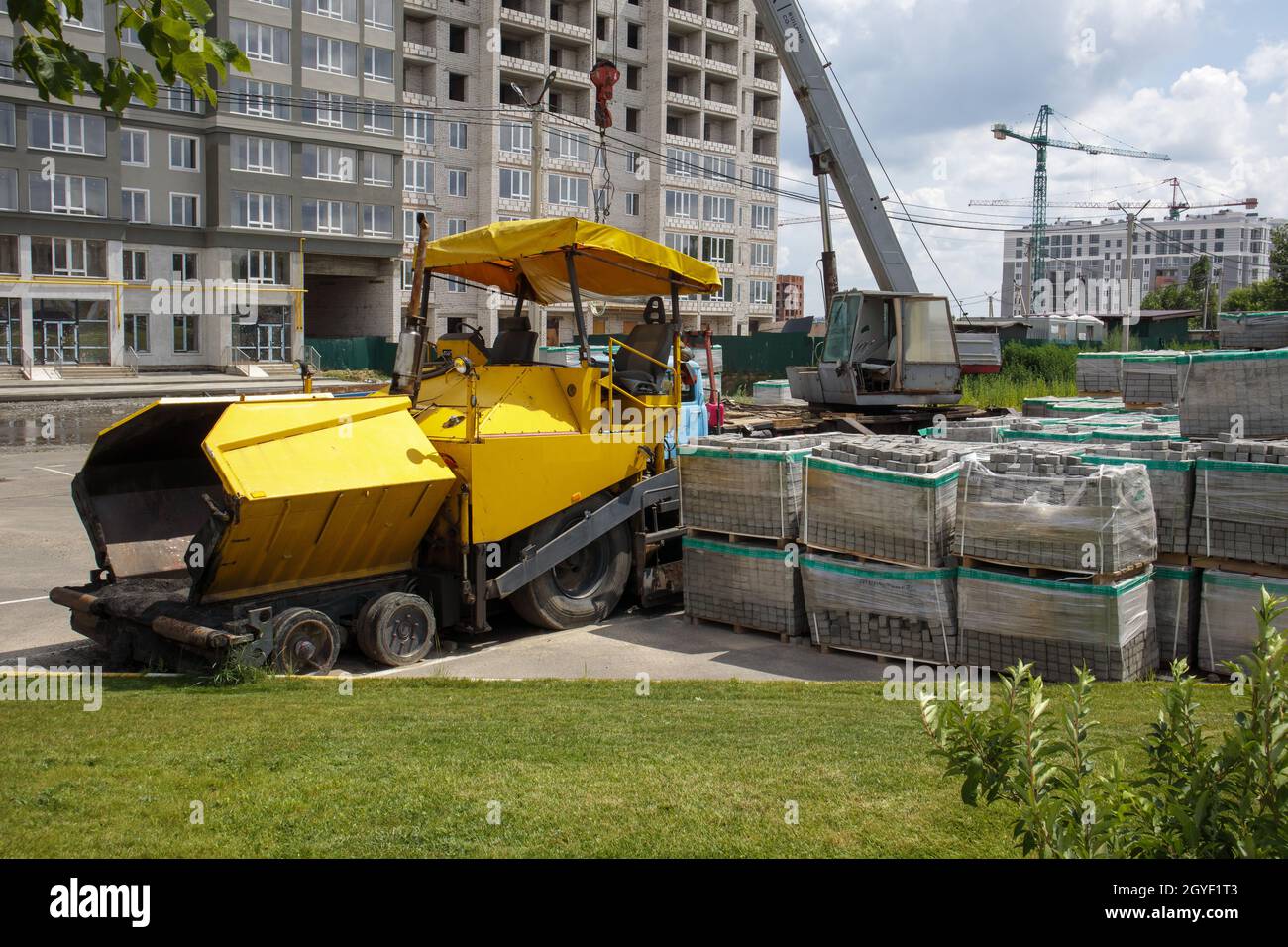 Un'asfaltatrice è parcheggiata in un cantiere. I macchinari per la costruzione di strade si trovano in un magazzino. Costruzione di strade pesanti e REpaia Foto Stock