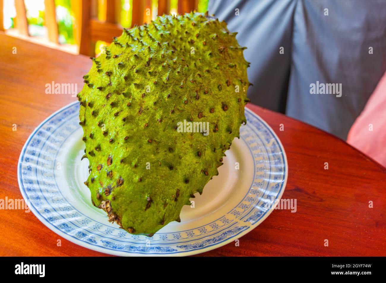 Soursop Sauersack Annona muricata frutta tropicale su piatto bianco e tavola di legno a Bentota Sri Lanka. Foto Stock
