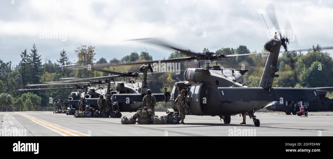 UH-60 elicotteri Black Hawk assegnati a 2-158 Assault Helicopter Battaglione 'Warhawks', sedicesimo combattimento Aviazione Brigata, carico soldati alla base congiunta Lewis-McChord, Washington, il 4 ottobre 2021. Il battaglione trasportava soldati della Stryker Brigade Combat Team del 1-2 in un esercizio combinato di addestramento sulle armi volto ad aumentare la preparazione al combattimento per le operazioni di emergenza. (STATI UNITI Foto dell'esercito di Capt. Kyle Abraham, sedicesimo brigata dell'aviazione di combattimento) Foto Stock