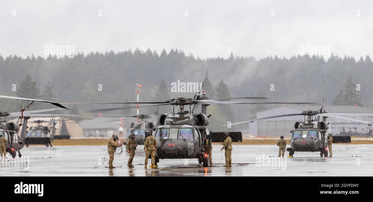 UH-60 i membri dell'equipaggio di elicotteri Black Hawk assegnati a 2-158 Battaglione di elicotteri Assault 'Warhawks', sedicesima brigata dell'aviazione di combattimento, iniziano le operazioni pre-volo alla Joint base Lewis-McChord, Washington, il 5 ottobre 2021. I soldati si preparavano a trasportare i soldati della Stryker Brigade Combat Team del 1-2 in un esercizio combinato di addestramento sulle armi volto ad aumentare la preparazione al combattimento per le operazioni di emergenza. (STATI UNITI Foto dell'esercito di Capt. Kyle Abraham, sedicesimo brigata dell'aviazione di combattimento) Foto Stock