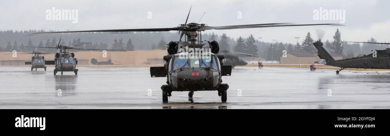 UH-60 elicotteri Black Hawk assegnati a 2-158 Assault Helicopter Battaglione 'Warhawks', sedicesimo combattimento Aviazione Brigata, carico soldati alla base congiunta Lewis-McChord, Washington, il 5 ottobre 2021. Il battaglione trasportava soldati della Stryker Brigade Combat Team del 1-2 in un esercizio combinato di addestramento sulle armi volto ad aumentare la preparazione al combattimento per le operazioni di emergenza. (STATI UNITI Foto dell'esercito di Capt. Kyle Abraham, sedicesimo brigata dell'aviazione di combattimento) Foto Stock