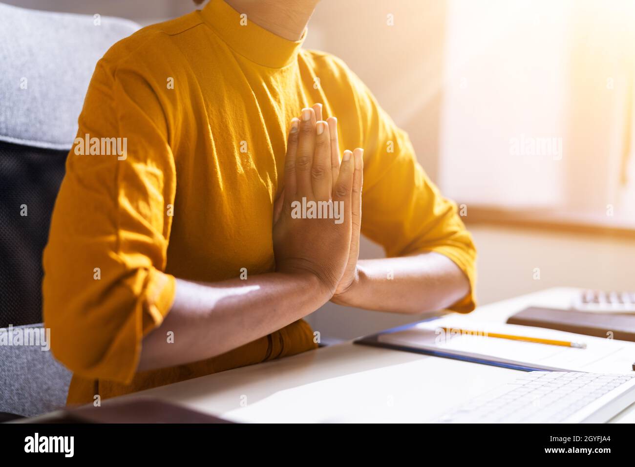 Donna afroamericana che prega in ufficio. Dio prega Foto Stock