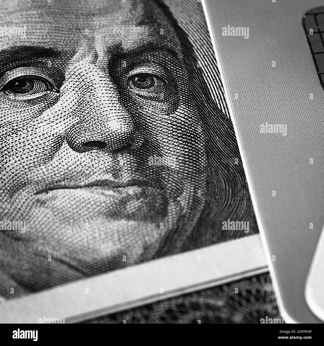 Il volto di Benjamin Franklin su un conto di cento dollari accanto ad una carta di credito. Primo piano. Un conto americano di cento dollari con gli occhi di Benjamin Franklin. Foto Stock