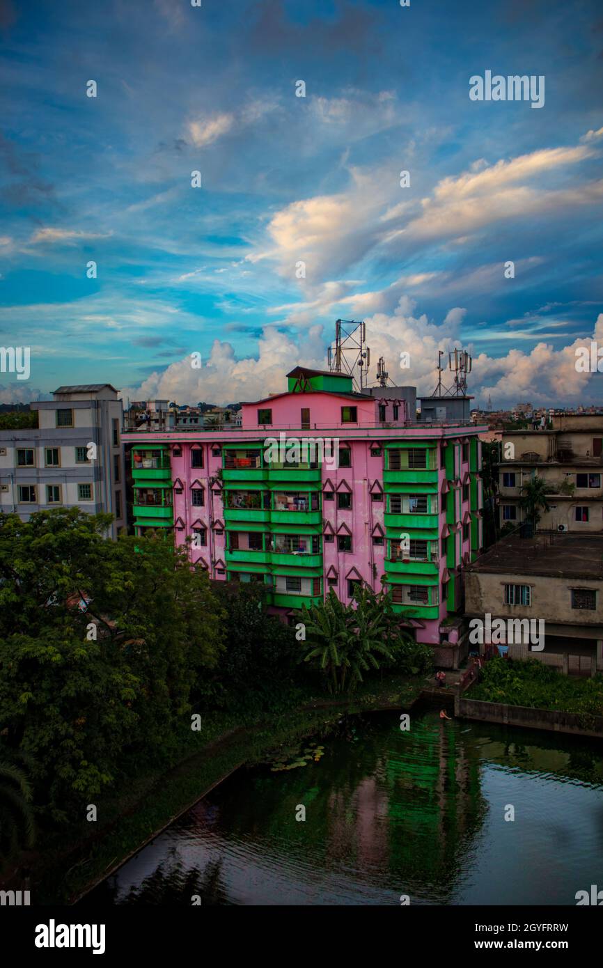 Un edificio sul lago e alcuni alberi con cielo blu nuvoloso. Agrabad, Chittagong, Bangladesh. Foto Stock