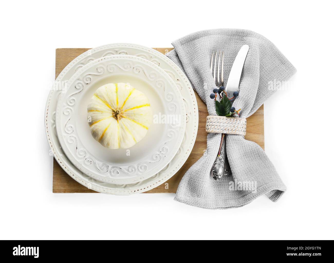 Tavolo per il ringraziamento con zucca, posate e tovagliolo su sfondo bianco Foto Stock