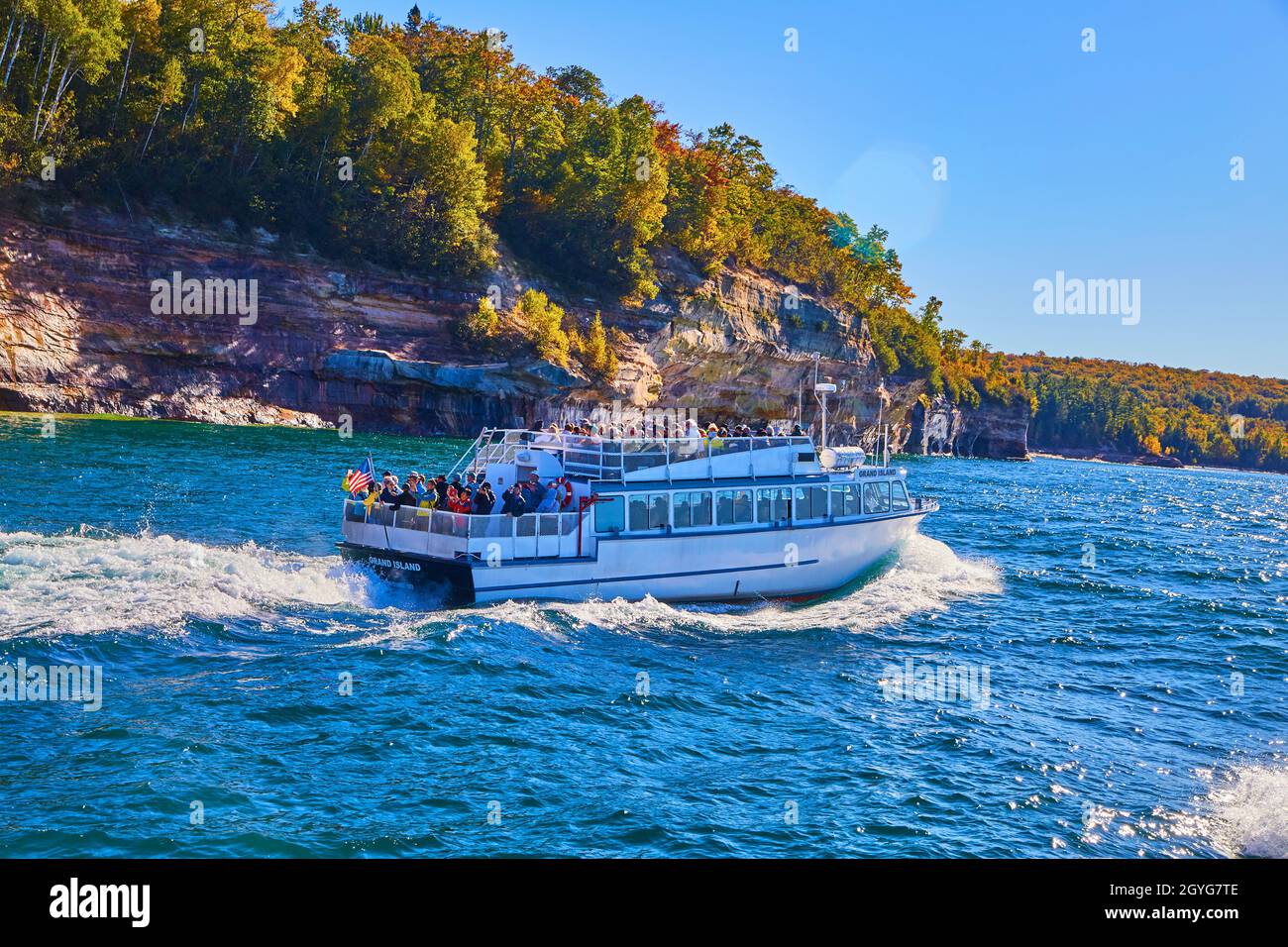 Tour in barca delle rocce raffigurate sul lago michigan con onde ondate e scogliere Foto Stock
